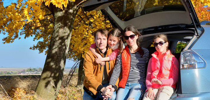 family enjoying the fall foliage while on a road trip