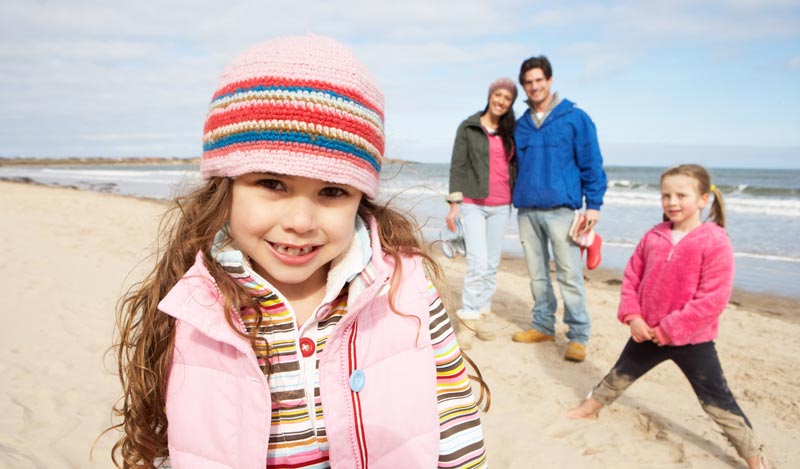 parents with two young girls at the beach